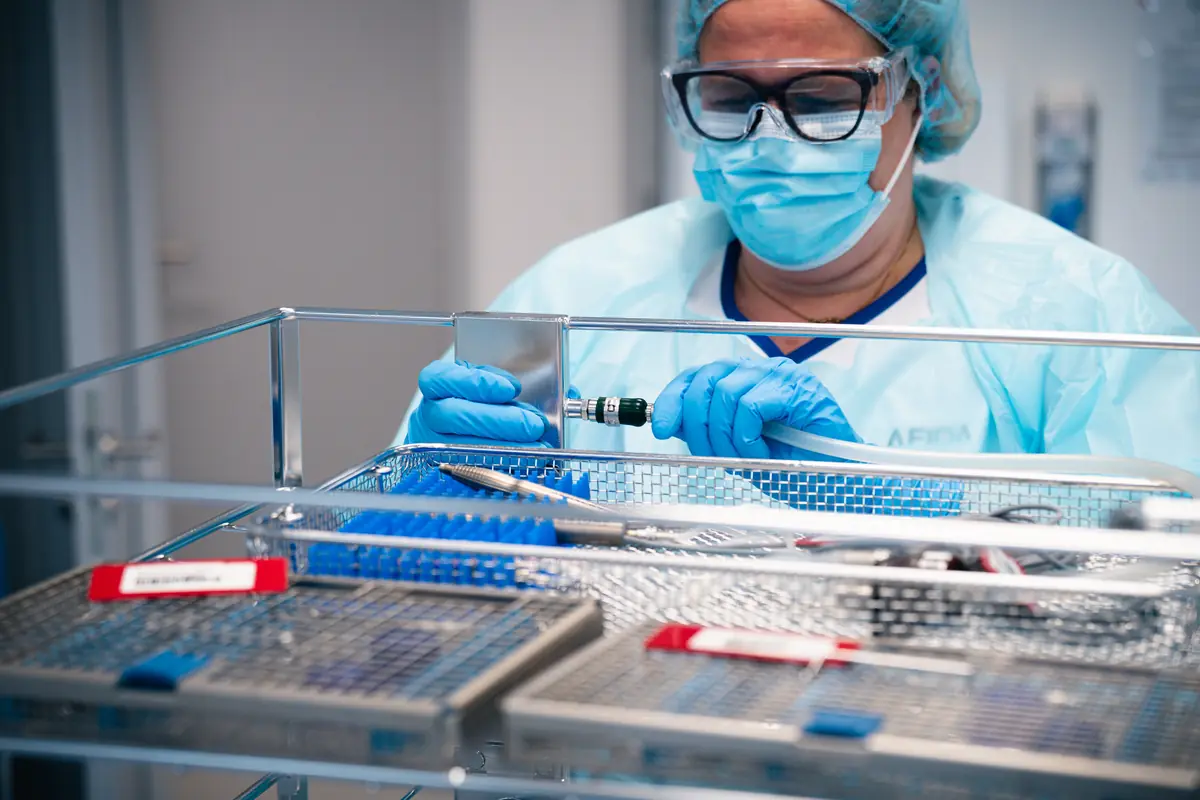 Mitarbeiterin von AFIDA steril bei der Kontrolle eines Instrumentensiebs